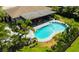Aerial view of a home with a kidney-shaped pool, patio, and lush tropical landscaping at 13916 Wellesford Way, Tampa, FL 33624