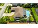 Aerial view of a home with a backyard pool, patio, and driveway in a residential neighborhood at 13916 Wellesford Way, Tampa, FL 33624