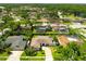 Aerial view showing several neighborhood homes, some with screened pools, surrounded by mature trees at 13916 Wellesford Way, Tampa, FL 33624