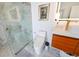 Bathroom featuring walk-in shower with glass, modern toilet, wood vanity with rectangular sink, and art at 13916 Wellesford Way, Tampa, FL 33624