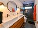 Modern bathroom with double sinks, a wood vanity, and walk-in shower at 13916 Wellesford Way, Tampa, FL 33624