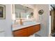 Bathroom vanity featuring wood cabinets, white countertop, a gold faucet, and decorative lighted mirror at 13916 Wellesford Way, Tampa, FL 33624