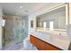 Bathroom featuring glass enclosed shower with marble, wood vanity with rectangular sink, and a LED lighted mirror at 13916 Wellesford Way, Tampa, FL 33624