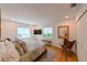 Cozy bedroom with hardwood floors, natural light, and a mounted television at 13916 Wellesford Way, Tampa, FL 33624