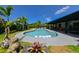 Kidney-shaped swimming pool with tropical landscaping and an outdoor seating area at 13916 Wellesford Way, Tampa, FL 33624