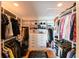 Spacious walk-in closet with custom shelving, drawers, and ample storage space for clothes and accessories at 13916 Wellesford Way, Tampa, FL 33624
