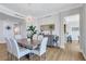Bright dining area with elegant chandelier lighting, a gray table, and stylish décor, with access to a kitchen at 140 Riviera Dunes Way # 1203, Palmetto, FL 34221