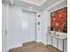 Bright hallway with elevator access, wood floors, stylish furniture and artwork at 140 Riviera Dunes Way # 1203, Palmetto, FL 34221