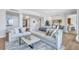 Spacious living room featuring modern décor and a large sectional sofa with light-colored wood flooring throughout at 140 Riviera Dunes Way # 1203, Palmetto, FL 34221