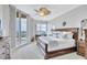 Bright main bedroom featuring a decorative ceiling fan and sliding glass doors to a balcony at 140 Riviera Dunes Way # 1203, Palmetto, FL 34221