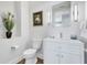 Clean and bright powder room with a modern vanity, decorative mirror, and stylish lighting fixtures at 140 Riviera Dunes Way # 1203, Palmetto, FL 34221