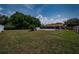 Expansive backyard featuring a swimming pool, screened patio, and lush green lawn at 1402 Oleander Dr, Tarpon Springs, FL 34689