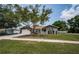 Single-story home with manicured lawn, paved driveway, and inviting curb appeal at 1402 Oleander Dr, Tarpon Springs, FL 34689