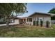 Charming single-story home with stone facade, well-manicured lawn, and garage at 1402 Oleander Dr, Tarpon Springs, FL 34689