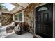 Cozy front porch with stone accents and seating area by a modern black front door at 1402 Oleander Dr, Tarpon Springs, FL 34689