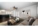 Spacious living room featuring dark wood-look floors, neutral wall color, ceiling fan, and bright kitchen at 1402 Oleander Dr, Tarpon Springs, FL 34689