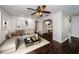 Bright living room featuring dark wood-look flooring, ceiling fan, and neutral wall color scheme at 1402 Oleander Dr, Tarpon Springs, FL 34689