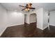 Bright living room featuring dark wood-look flooring, ceiling fan, and neutral wall color scheme at 1402 Oleander Dr, Tarpon Springs, FL 34689