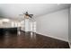 Spacious living room featuring dark wood-look floors, neutral wall color, ceiling fan, and bright kitchen at 1402 Oleander Dr, Tarpon Springs, FL 34689