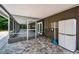 View of paved patio looking into screened-in porch and backyard at 1402 Oleander Dr, Tarpon Springs, FL 34689