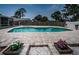 View of the backyard pool and patio with planter boxes under blue skies at 1402 Oleander Dr, Tarpon Springs, FL 34689
