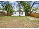 View of a charming backyard featuring lush trees, and a partially fenced yard at 1404 E Curtis St, Tampa, FL 33603