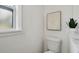 Bathroom with a modern toilet beneath a window, featuring white walls and stylish decor, creating a serene ambiance at 1404 E Curtis St, Tampa, FL 33603