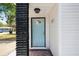 The light-colored front door surrounded by a textured column and brick provides charm and welcomes guests to this inviting home at 1404 E Curtis St, Tampa, FL 33603