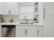Close-up showcasing the kitchen's sink, window, and stylish white cabinets with gold hardware at 1404 E Curtis St, Tampa, FL 33603