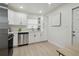 Well-lit kitchen with modern appliances, white cabinets and counter tops, and contemporary fixtures at 1404 E Curtis St, Tampa, FL 33603