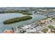 Wide aerial view of waterfront homes with docks, showcasing a canal and a large marina in the distance at 1421 Sea Gull S Dr, St Petersburg, FL 33707
