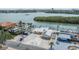 Waterfront property featuring a dock, boat lift, metal roof, solar panels, and a paved driveway at 1421 Sea Gull S Dr, St Petersburg, FL 33707
