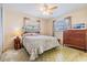 Bedroom with a seashell-themed comforter, wood dresser, and natural light from the window at 1421 Sea Gull S Dr, St Petersburg, FL 33707