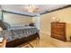 Bedroom with a fan, desk and dresser, with a patterned bedspread and accent border at 1421 Sea Gull S Dr, St Petersburg, FL 33707