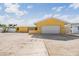 Exterior of well maintained yellow home with two car garage and desert landscaping at 1421 Sea Gull S Dr, St Petersburg, FL 33707