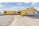 Charming exterior view of yellow home with metal roof, desert landscaping, and decorative door at 1421 Sea Gull S Dr, St Petersburg, FL 33707