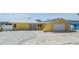 Charming yellow home featuring a metal roof, solar panels, white rock landscaping, and a paved driveway at 1421 Sea Gull S Dr, St Petersburg, FL 33707