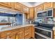 Kitchen features stainless appliances, light wood cabinets, neutral counters, and an open view at 1421 Sea Gull S Dr, St Petersburg, FL 33707
