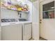 Bright laundry room featuring a modern washer and dryer, organized shelving, and easy outdoor access at 1421 Sea Gull S Dr, St Petersburg, FL 33707