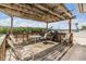 Waterfront covered outdoor deck featuring wood floors, seating, grill, and views of the marina at 1421 Sea Gull S Dr, St Petersburg, FL 33707