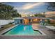 Inviting backyard featuring a refreshing pool, patio seating, and well-manicured landscaping at 14626 Wildwood Dr, Largo, FL 33774