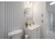Stylish bathroom with a patterned wall, modern vanity, and round mirror at 14626 Wildwood Dr, Largo, FL 33774