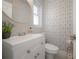 Modern bathroom with a round mirror, sink, vanity and geometric wallpaper at 14626 Wildwood Dr, Largo, FL 33774