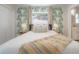 Bright bedroom with closet, window, and palm-leaf design and view into the bathroom at 14626 Wildwood Dr, Largo, FL 33774