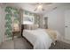 Light-filled bedroom featuring a ceiling fan, area rug and palm-leaf patterned accent wall at 14626 Wildwood Dr, Largo, FL 33774