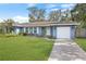 Charming single-story home with a well-manicured lawn and a driveway leading to an attached garage at 14626 Wildwood Dr, Largo, FL 33774