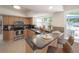 Open concept kitchen with stainless appliances, dark countertops, and breakfast bar overlooking the backyard at 14626 Wildwood Dr, Largo, FL 33774