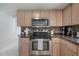 Well-equipped kitchen with stainless steel appliances, wood cabinets, and tile backsplash at 14626 Wildwood Dr, Largo, FL 33774