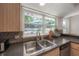 This kitchen features a stainless sink with a window overlooking the pool and backyard at 14626 Wildwood Dr, Largo, FL 33774