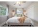 Bright bedroom featuring a ceiling fan, large windows, and a closet at 14626 Wildwood Dr, Largo, FL 33774